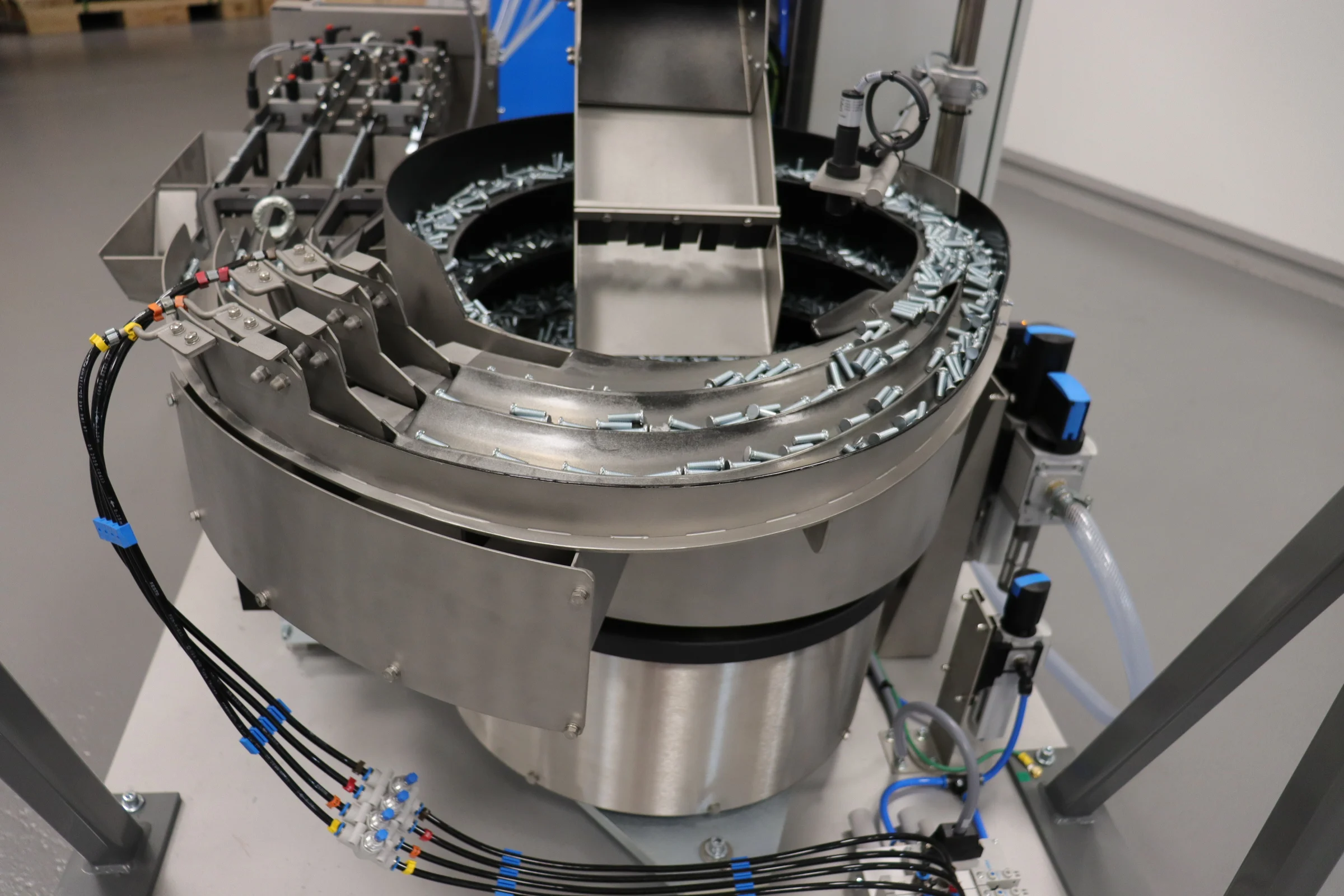 PEMSERTER IN-DIE自动送料系统的特写，展示其将压铆紧固件输送至压装机。