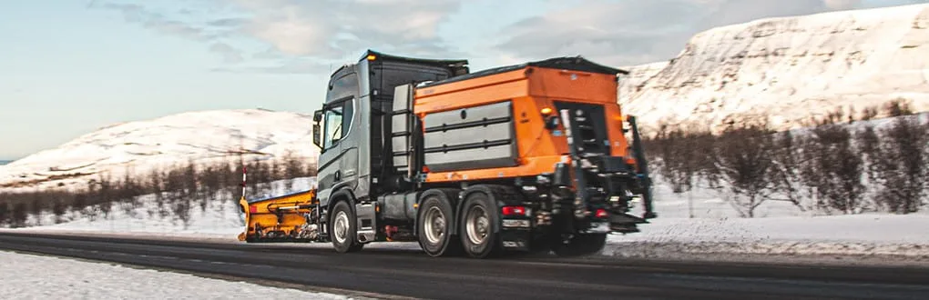 
Epoke冬季道路维护设备在积雪覆盖的山旁的道路上。
