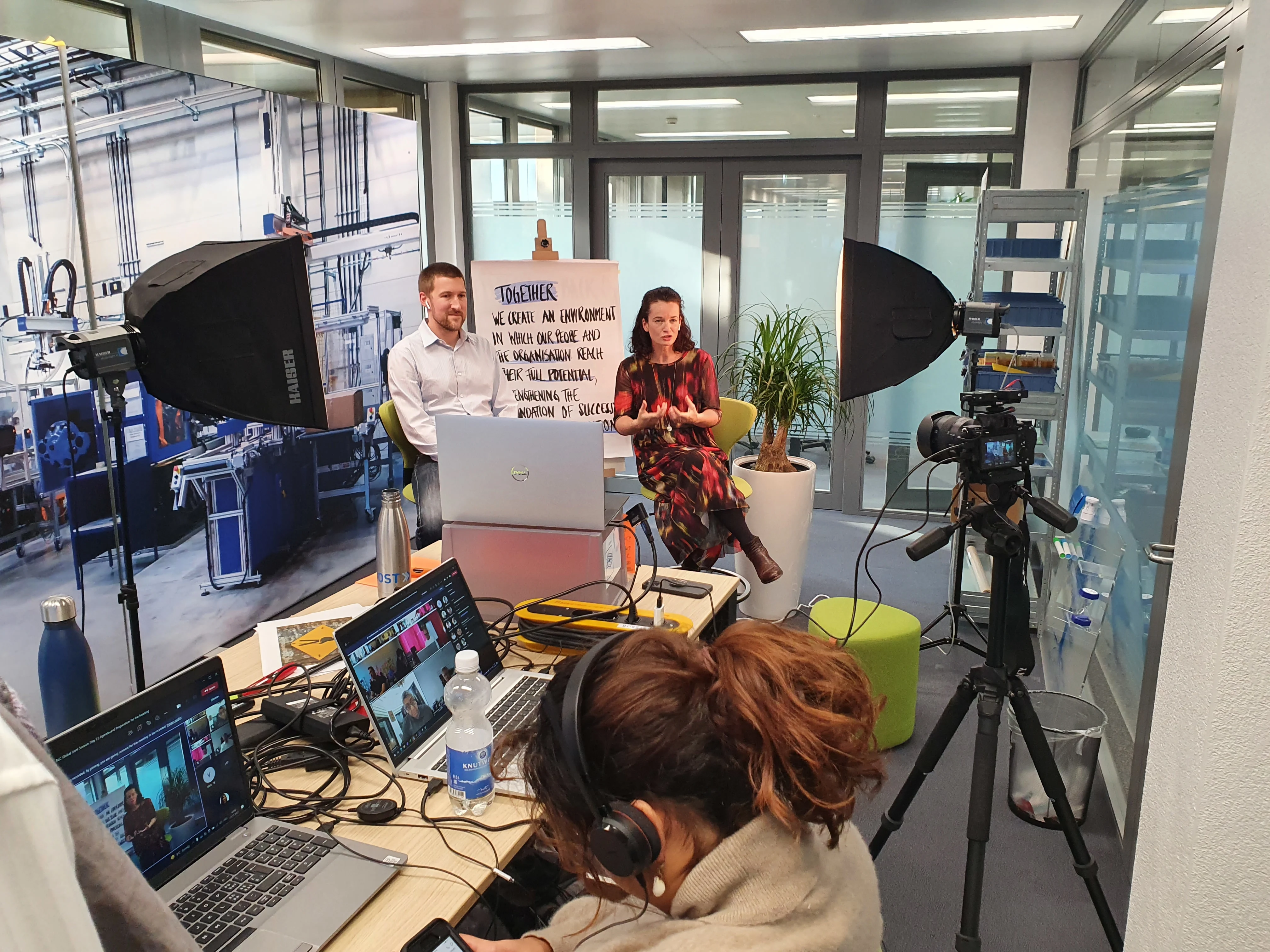 一群人在Bossard的视频录制工作室中合作使用笔记本电脑，正在进行录制。