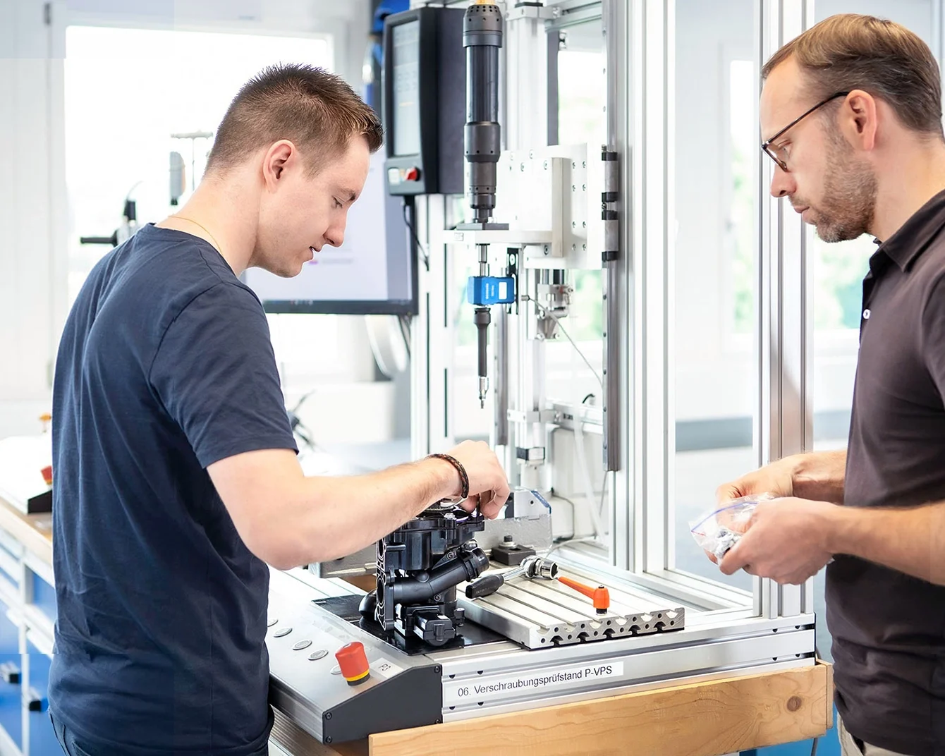 两名工程师正在测试台上进行扭矩分析的测试设置。