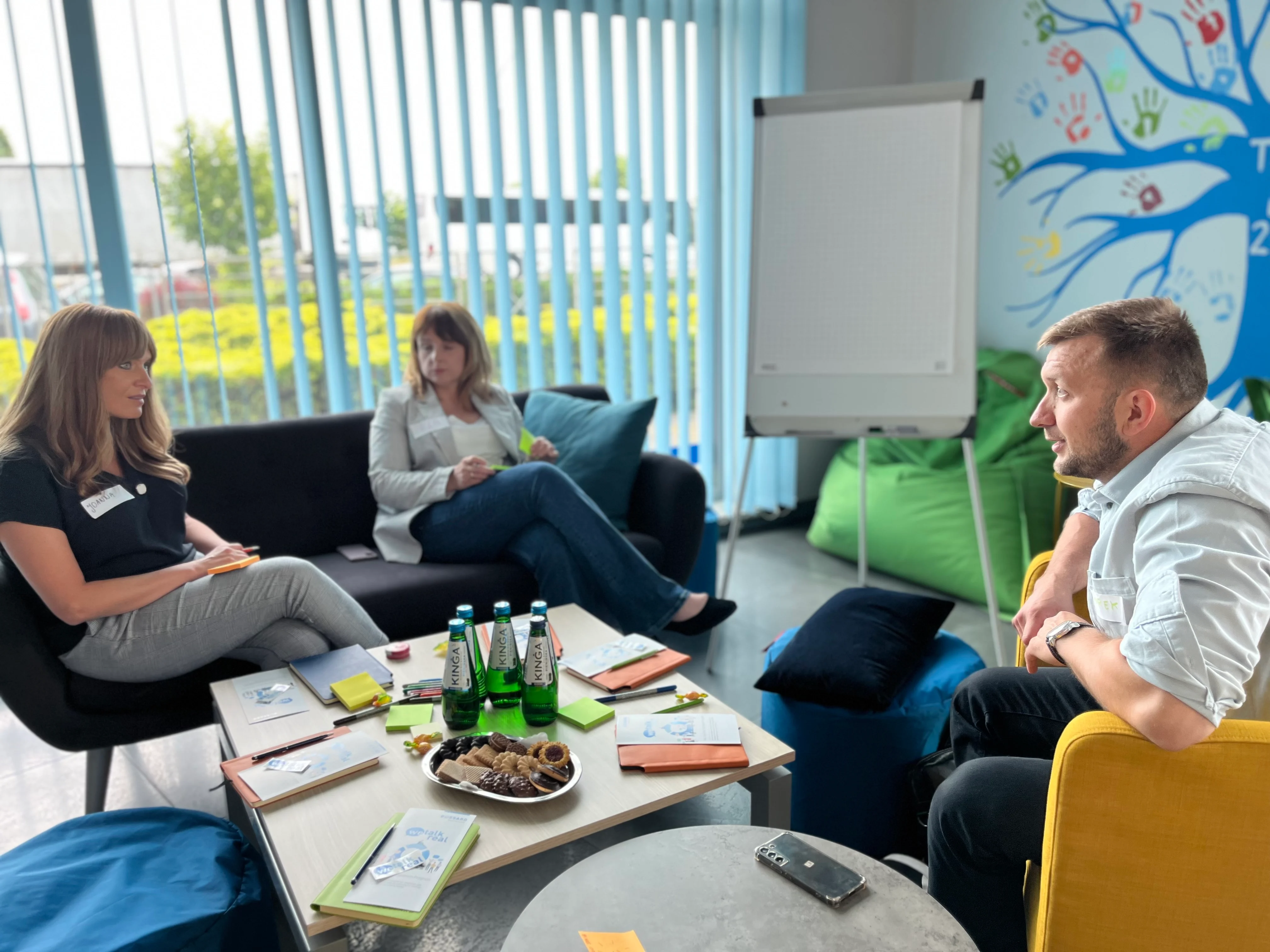 一群人围坐在一间装饰着鲜艳多彩墙壁的房间里。