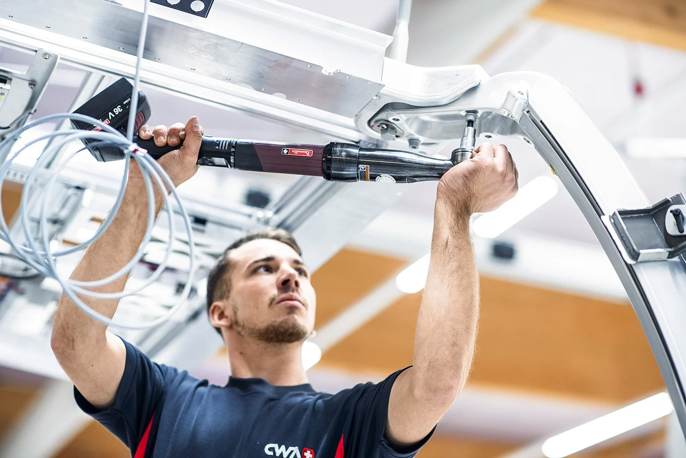 一个男人使用智能工具将螺钉拧入铝材中。